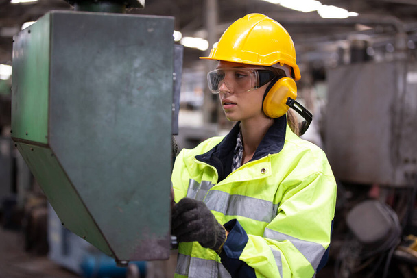 Las trabajadoras que usan gafas de seguridad controlan la máquina de torno para perforar componentes. Torno de metal fábrica de fabricación industrial - Foto, Imagen