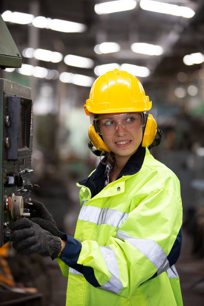 Mulher trabalhador usando óculos de segurança controle torno máquina para perfurar componentes. Torno de metal fábrica de fabricação industrial - Foto, Imagem