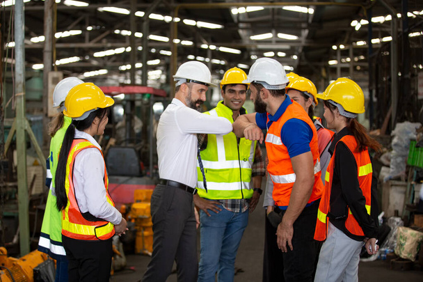 grupo de trabajadores, cambio de trabajadores en la fábrica, personas van en cascos y uniformes para una empresa industrial - Foto, imagen