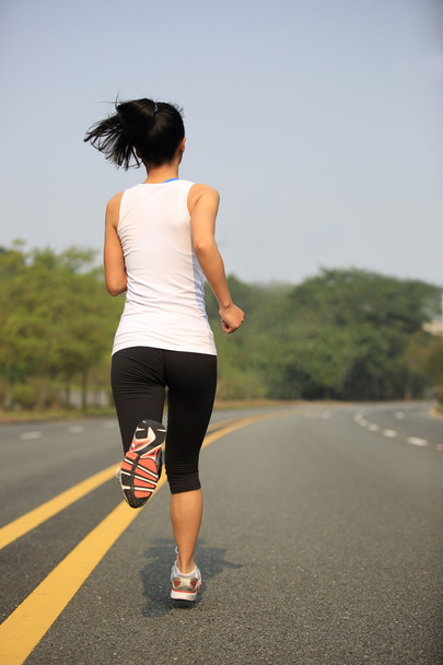 Sporty woman jogging at tropical park - Fotoğraf, Görsel