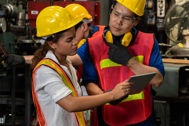 Gruppe geschickter Arbeiter mit Maschinenausrüstung in der Fabrikhalle - Foto, Bild
