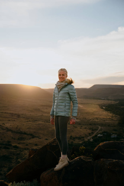 Bela caminhada feminina caucasiana em um topo da montanha desfrutando do pôr do sol - Foto, Imagem