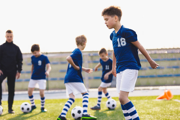 Football Education for Kids. Physical Education for Children. Young Coach With Kids in Soccer Team on Training Unit. Youth Team Coach Training School Boys in Football Soccer - Photo, Image