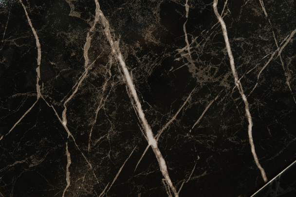 fond noir, marbre poli avec des stries blanches, vue sur le dessus - Photo, image