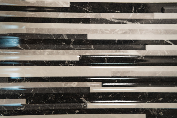Hintergrund aus schwarz-weißen, glänzenden Keramikfliesen, mit Marmorimitat, Draufsicht - Foto, Bild