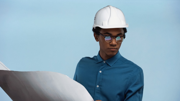 afroamericano adolescente en casco de seguridad celebración plano aislado en azul - Foto, Imagen