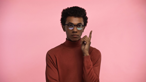 Африканский американский подросток в водолазке свитер и очки с идеей изолированы на розовый - Фото, изображение