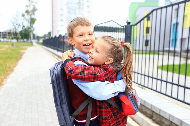 Niños con maletines sobre sus hombros en el fondo de la escuela. - Foto, Imagen