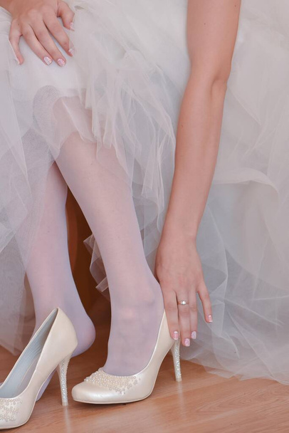 The bride puts on her wedding shoes. - Photo, Image