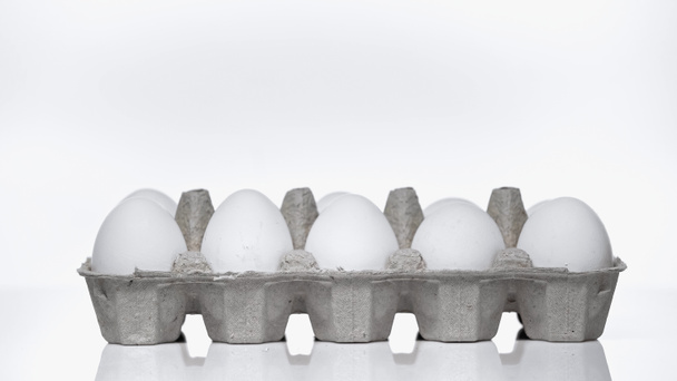 χαρτοκιβώτιο με ωμά αυγά σε λευκό - Φωτογραφία, εικόνα