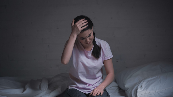 brunette jeune femme souffrant de maux de tête la nuit - Photo, image