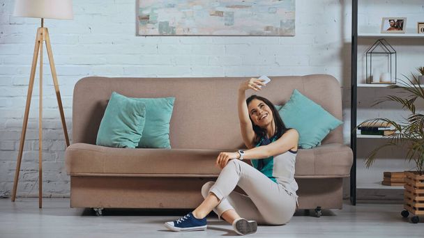 šťastná žena se selfie v obývacím pokoji  - Fotografie, Obrázek
