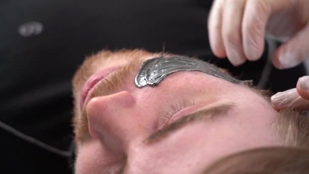 Fogantatás kozmetológia és arc. Nő kozmetikus teszi arc és szakáll modellezés férfi gyantázás epiláció - Felvétel, videó