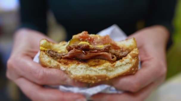 Vrouw knijpen hamburger in fast food restaurant. - Video