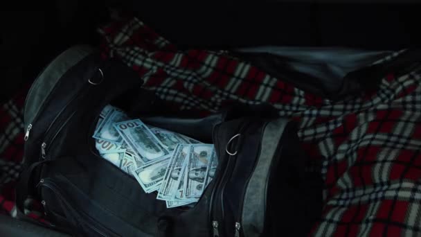 Eldivenli bir el bagajdan para dolu bir çanta çıkarır. - Video, Çekim