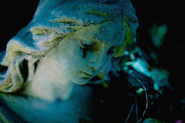 Concept de mort. Une ancienne statue en pierre d'ange pleurant avec des larmes au visage comme symbole de fin de douleur et de vie humaine.  - Photo, image