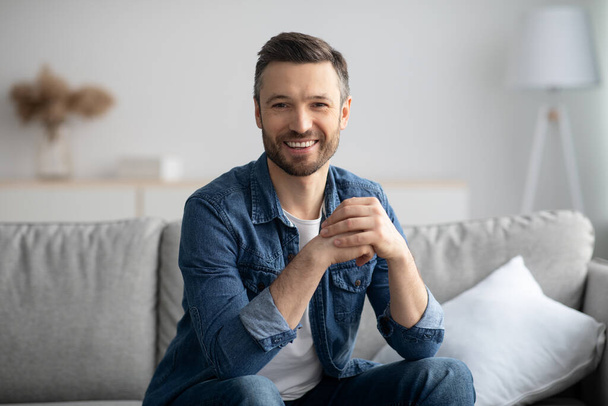Handsome middle-aged man in casual posing in living room - Photo, Image