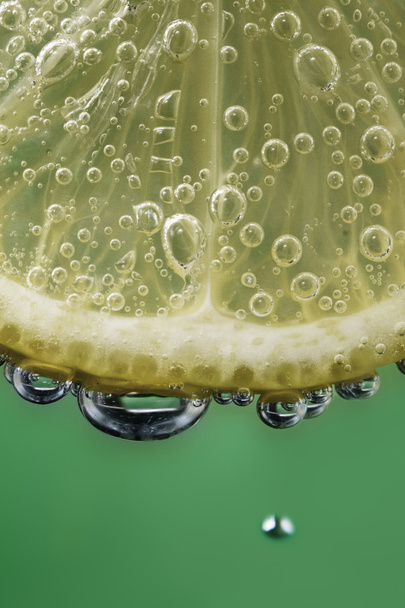 Лимонный ломтик в пузырьках зеленого цвета
 - Фото, изображение