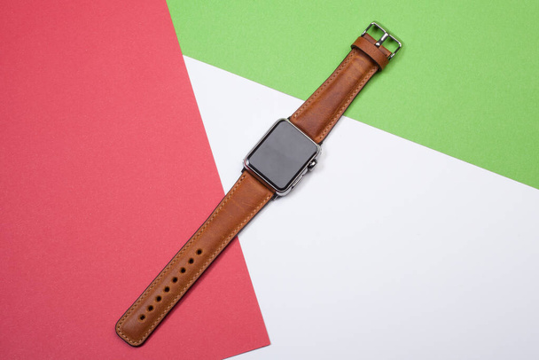red and green geometric background, electronic clock and leather watchband - Photo, Image