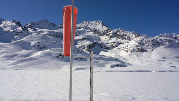 Dağın tepesi tamamen kar ve buzla kaplı. Sinyaller, rüzgarı tespit etmek için aletler ve İsviçre Alpleri 'ndeki Pizza Pal' de yere düşen karın yüksekliği. - Fotoğraf, Görsel