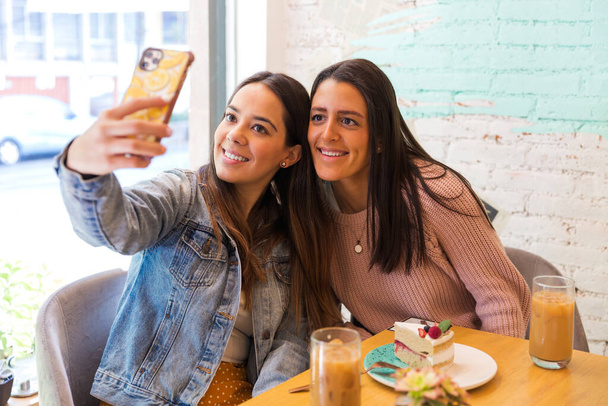 Retrato de dos hermosas novias tomando foto selfie en una cafetería - Foto, imagen