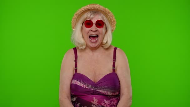 Zdumiewający emerytka kobieta turysta w stroju kąpielowym zszokowany nagłym zwycięstwem mówiąc wow na chroma klucz - Materiał filmowy, wideo