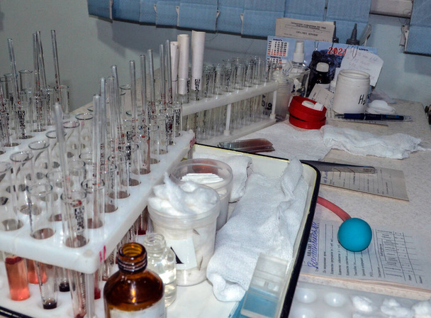 Tubos de teste médicos para análise de sangue e urina no fundo do microscópio borrado especialmente. - Foto, Imagem