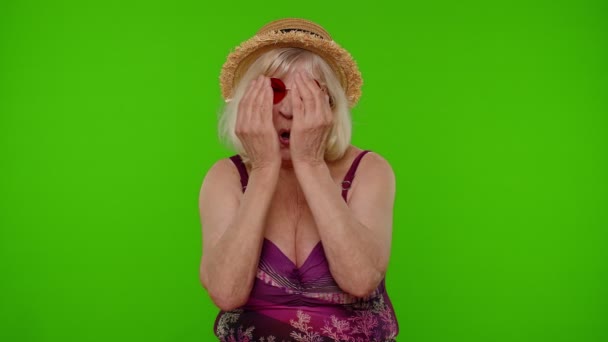 Vicces, buta idős nő turista fürdőruhában, hülyéskedik, hülye, agyatlan arckifejezéssel. - Felvétel, videó