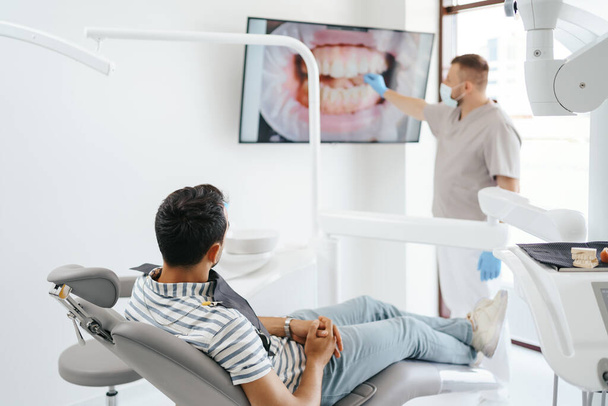 Dentiste expliquant l'image des dents à l'écran - Photo, image