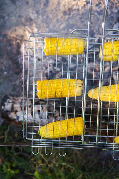 Maïs frits de maïs jaune juteux cuit sur un support métallique. Week-end, loisirs de plein air - Photo, image