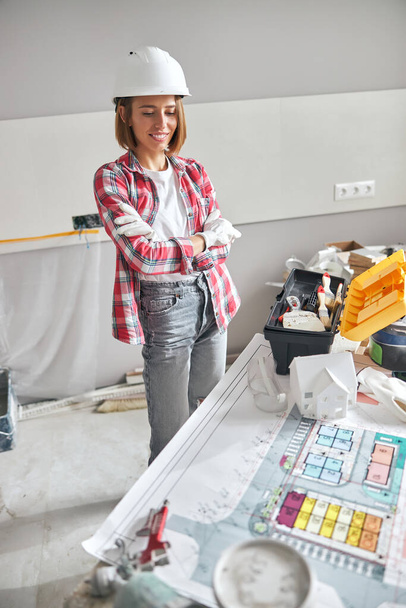 Pleased woman architect staring at a house plan - Photo, Image