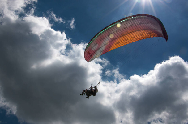 Опытный летчик-парапланерист, летящий на двух парапланерных креслах - Фото, изображение