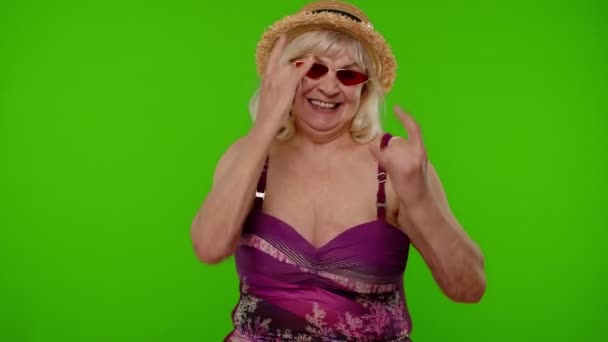 Seniorin im Badeanzug tanzt, feiert, zeigt Zunge, Rock "n" Roll-Geste - Filmmaterial, Video