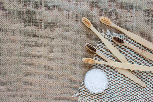 Bathroom essentials in zero waste home - bamboo toothbrushes and kaolin dentifrice, tooth powder made with natural ingredients or dental salt, on rustic background with copy space, selective focus - Photo, Image