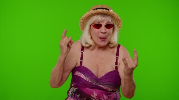 Seniorin im Badeanzug tanzt, feiert, zeigt Zunge, Rock "n" Roll-Geste - Filmmaterial, Video