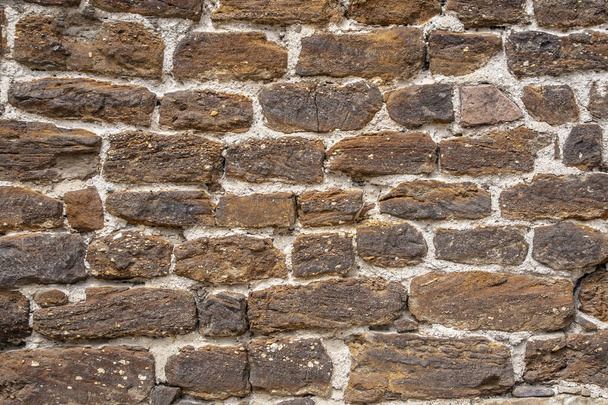 Een oude bruine kleuren stenen muur achtergrond. - Foto, afbeelding