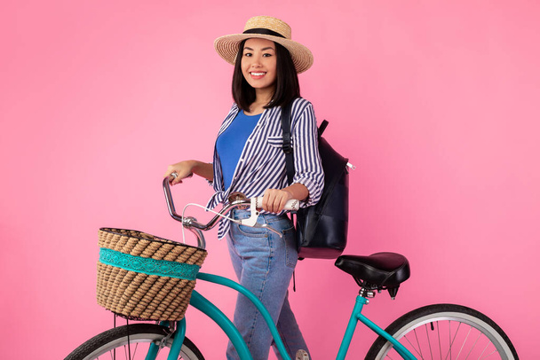 Asiática dama de pie con bicicleta retro con cesta de mimbre - Foto, imagen