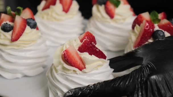 chef de pastelaria decora bolos Anna Pavlovas com frutas frescas e folhas de hortelã. - Filmagem, Vídeo