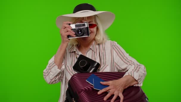 Senior γυναίκα τουρίστας φωτογράφος λήψη φωτογραφιών σε ρετρό κάμερα και χαμογελώντας σε chroma κλειδί φόντο - Πλάνα, βίντεο
