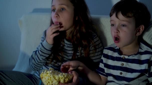 4k. little cute caucasian girl and boy watching films and eating popcorn - Footage, Video