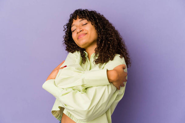 Young african american afro woman isolated hugs, smiling carefree and happy. - Foto, immagini