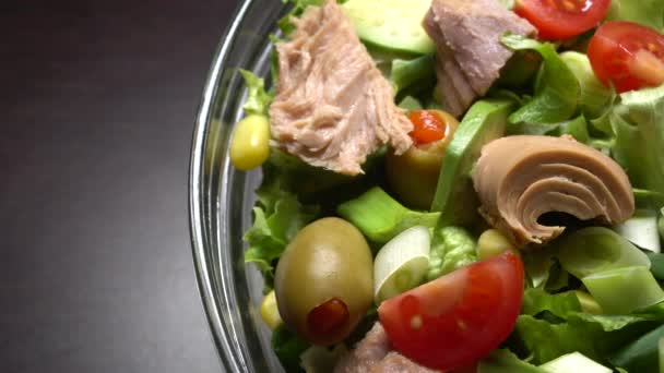 Tuna salad on a kitchen countertop with lettuce, olives, spring onions, cherry tomato, avocado, corn and canned tuna. Pan Right. Close up.  - Footage, Video