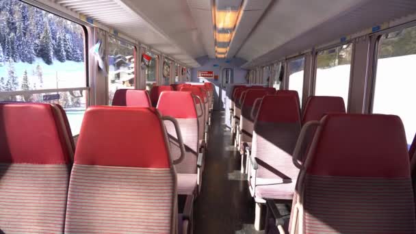 Europa, luty 2021 Alpy Szwajcarskie - Bernina Express, czerwony pociąg z Berniny Światowe dziedzictwo UNESCO - kolej retańska, wnętrze wagonu - Materiał filmowy, wideo