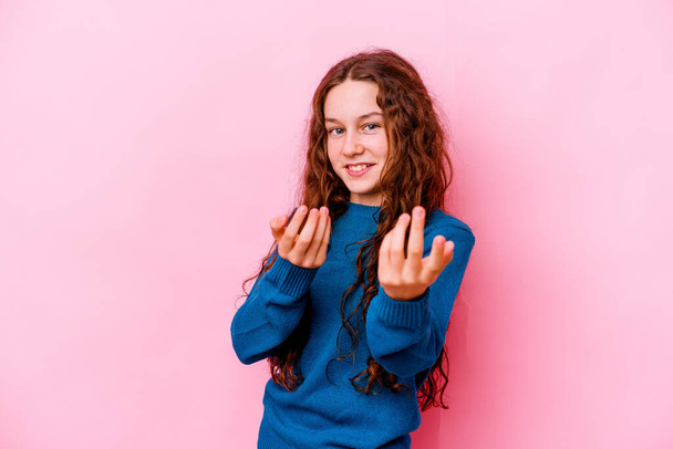 Little caucasian girl isolated on pink background pointing with finger at you as if inviting come closer. - Photo, Image