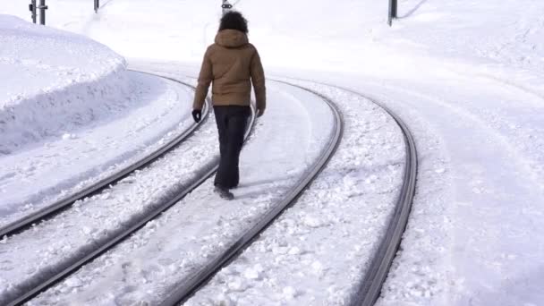 Мужчина 40 лет одиноко гуляет по замерзшим железнодорожным путям - звезда концепция путешествия в полярном ландшафте - Кадры, видео