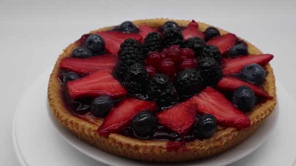 Tarta de frutas frescas con fresas, frambuesas, moras, aisladas sobre fondo blanco - Metraje, vídeo