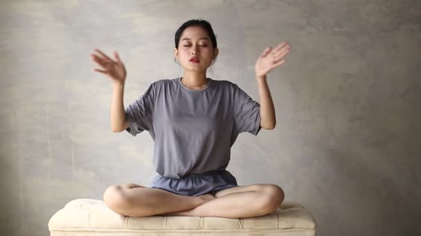 Ázsiai nő gyakorolja a meditációt bent, lótuszpozícióban. Nincs stressz, tudatosság, belső egyensúly koncepció - Felvétel, videó