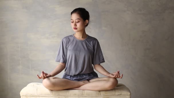 Donna asiatica pratica yoga meditare al chiuso, posizione del loto. Nessun stress, consapevolezza, concetto di equilibrio interiore - Filmati, video