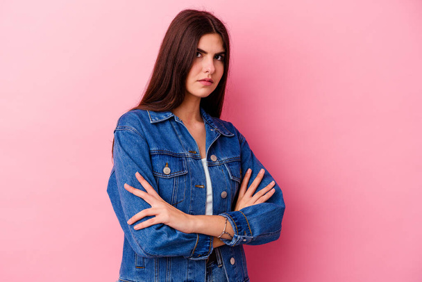 Young caucasian woman isolated on pink background frowning face in displeasure, keeps arms folded. - Photo, Image