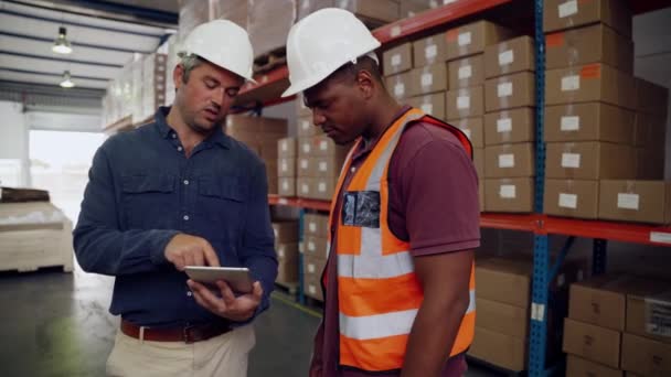 Manager antaa korjauksia työntekijä tilalla digitaalinen tabletti seisoo tehtaalla myymälä  - Materiaali, video